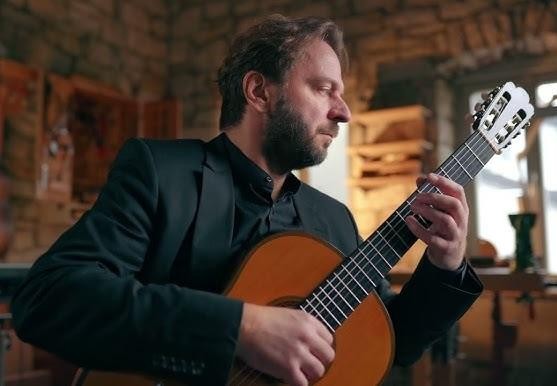 Młody Marcin Dylla ćwiczy grę na gitarze w szkole muzycznej.